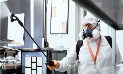 Exterminator spraying pesticides in office