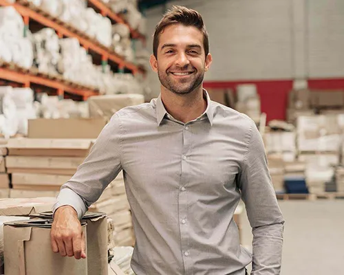 Warehouse manager standing in storage facility.