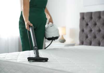 Woman steam cleaning mattress