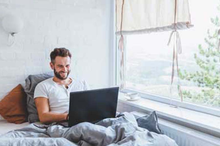 Man in bed with laptop