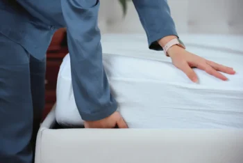 Person lifting a mattress checking for signs of bed bugs