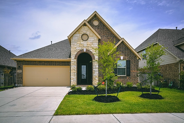 Suburban home with driveway and lush green lawn - Keep pests away from your home with Bug Out Pest Control in Texas
